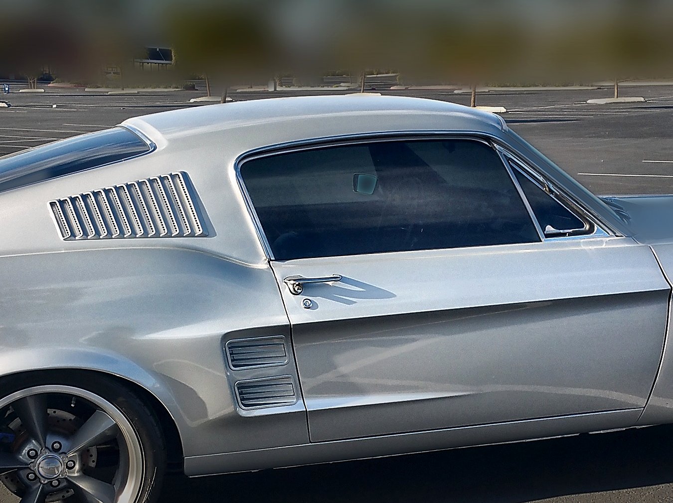 Side of Chad’s 1967 Mustang 2+2 Fastback in Brilliant Silver with rear quarter louvers and 18-inch wheels
