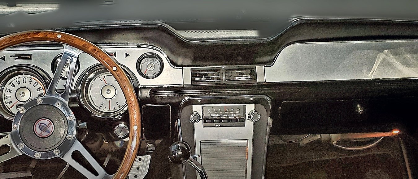 The Mustang’s dash with a wood-rimmed steering wheel, classic gauges and the center console